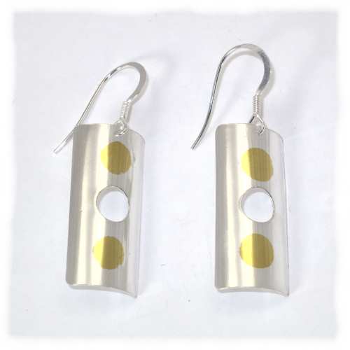 Cylindrical silver earrings with gold dots
